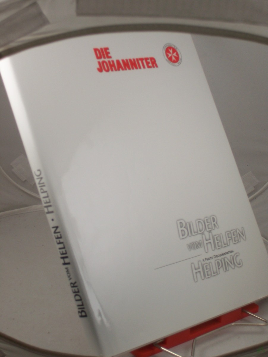 Product image 1 of the product “Bilder vom Helfen = Helping - a photo documentation : 1999 - im Jahre der 900-Jahrfeier des Johanniterordens / Die Johanniter. Hrsg.: Die Johanniter, der Bundesvorstand der Joha!nniter-Unfall-Hilfe e.V. Fotos: Stefan Trappe. Konzeption und ”